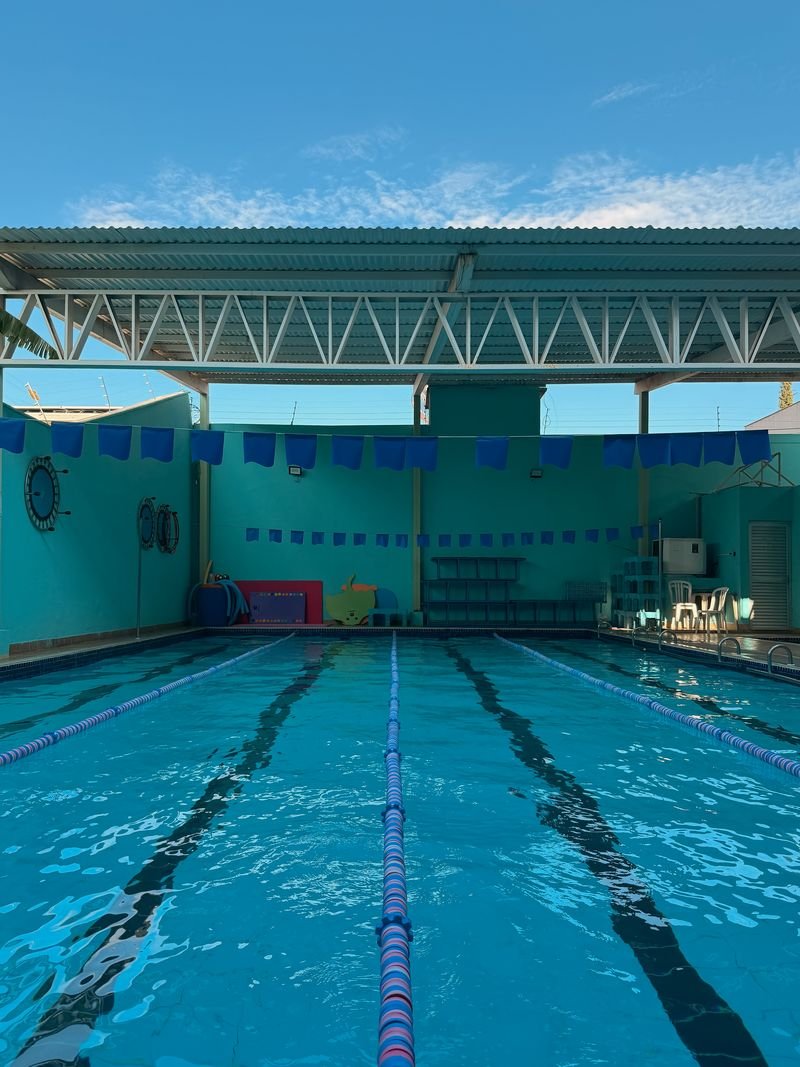 Piscina semiolímpica coberta e aquecida da Raia Acqua & Fit, com raias demarcadas e céu azul ao fundo
